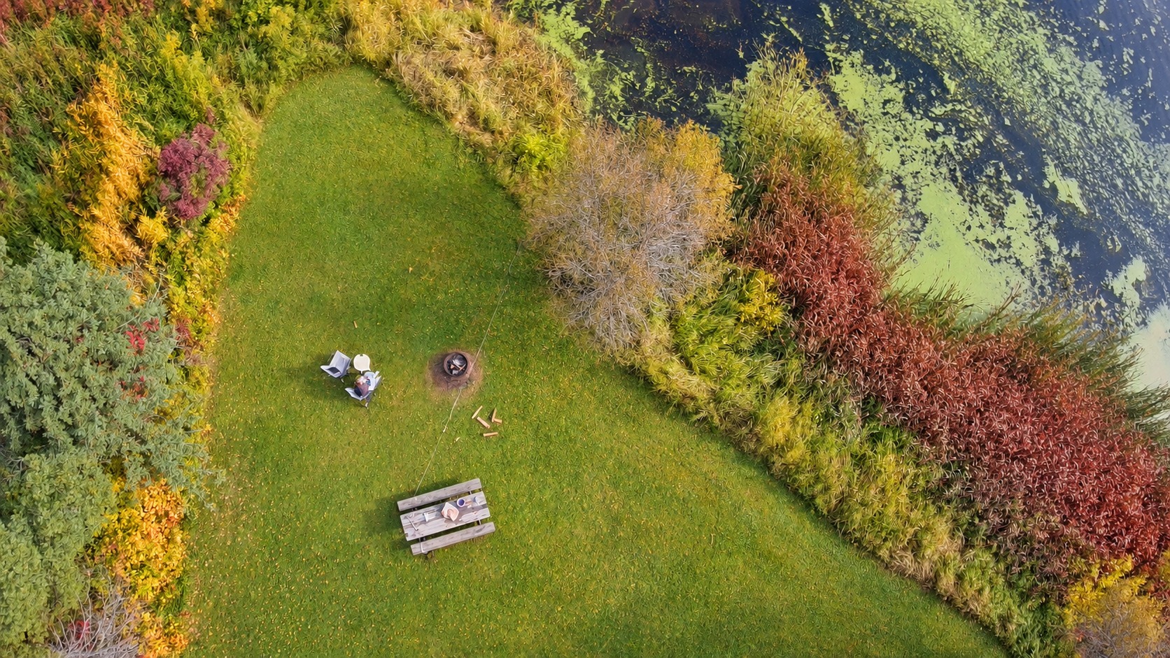 Our camp chairs and fire ring beside the water, photographed from above
