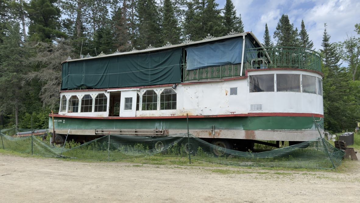 An old tour boat displayed on shore