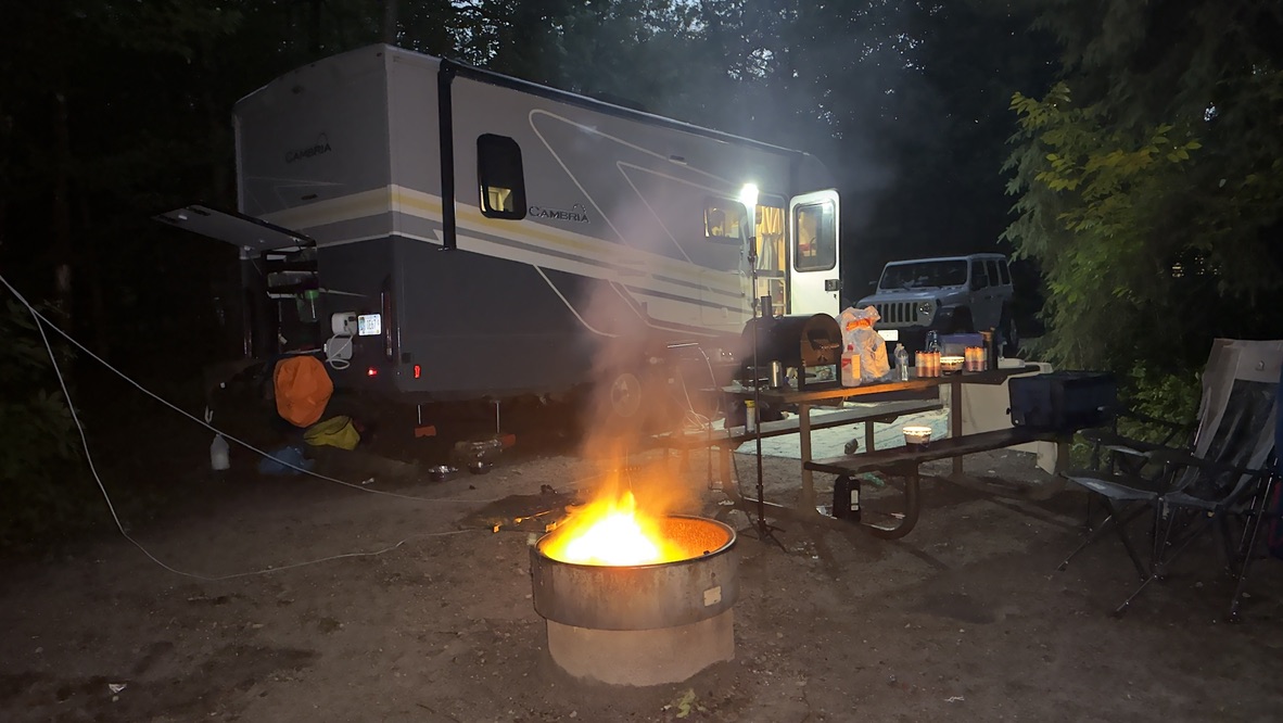 A glowing campfire beside the Chuckwagon Express at night