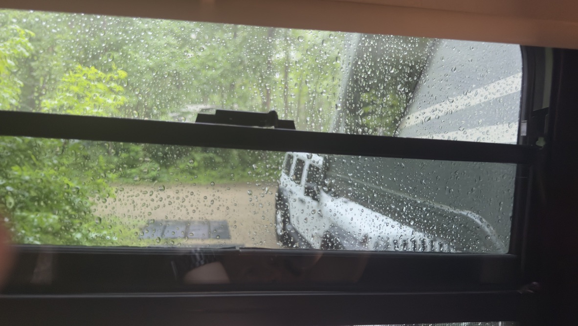 Rain on the RV window with the Dog House parked outside